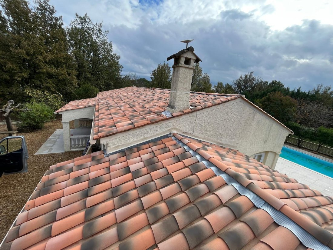 Artisan couvreur nettoyant une toiture en tuiles sous le soleil, style professionnel, haute qualité